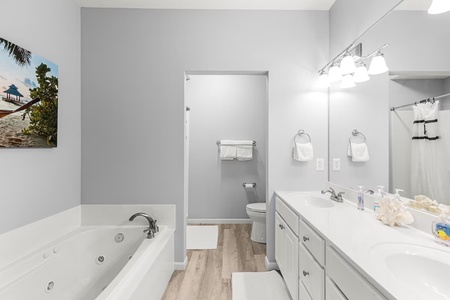 Unwind in your spacious bathroom featuring a luxurious jetted tub, modern vanity, and thoughtful amenities for a relaxing retreat.