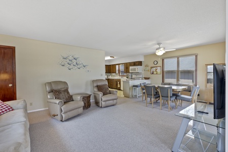 Relax in your spacious open-plan living area featuring comfortable seating, dining space, and fully equipped kitchen - perfect for memorable family gatherings.