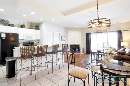 Kitchen table and bar seating. TV in cabinet above fireplace