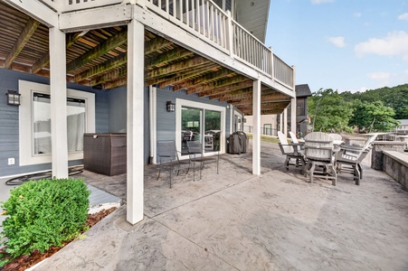 A spacious multi-level retreat with shaded seating and a hot tub, nestled in lush wooded surroundings for ultimate outdoor relaxation.