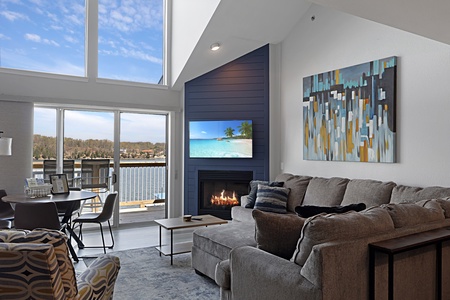 Cozy up by your fireplace while enjoying stunning lake views from this bright living space with soaring ceilings.