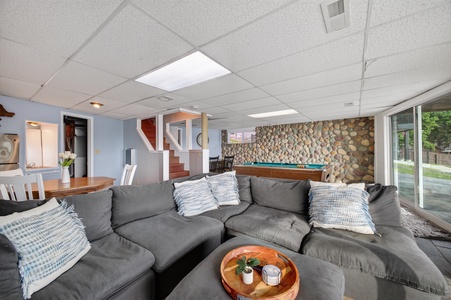 Sink into the plush sectional in your spacious living room, where a pool table awaits friendly competition and natural light pours through the glass doors.