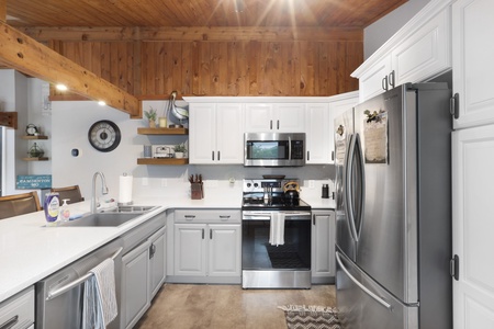 Step into your fully equipped kitchen with stainless appliances, warm wood accents, and a soaring vaulted ceiling, where cooking becomes a joy and gathering feels effortless.