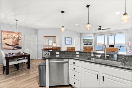 Your fully equipped kitchen flows into the dining area, with sparkling ocean views through floor-to-ceiling windows creating the perfect backdrop for meals.