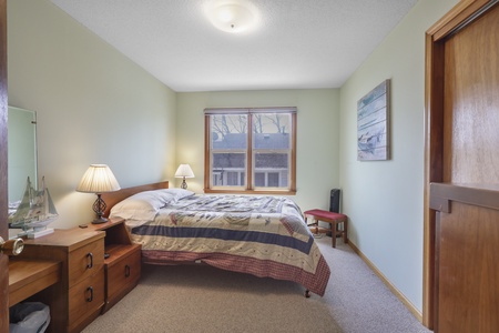 Drift off in your cozy bedroom with warm wood tones and soft natural light streaming through the window.
