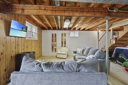 Your cozy basement retreat features plush seating, vintage skis, and entertainment for relaxing après-ski evenings together.