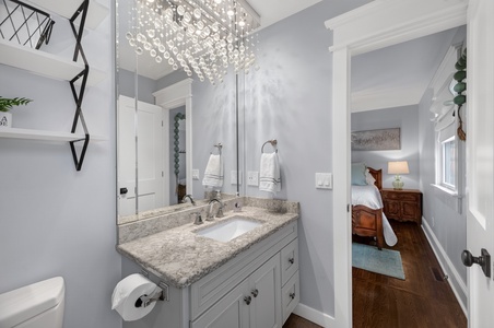 Step into your private bathroom with a sparkling chandelier, granite countertops, and plush towels waiting for you. The elegant vanity and soft lighting create a spa-like retreat where you can refresh after a day of exploring.