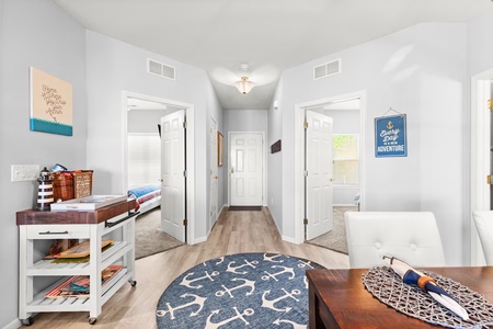 Your bright hallway connects thoughtfully designed spaces, with cheerful nautical touches and a rolling cart ready for your next adventure.