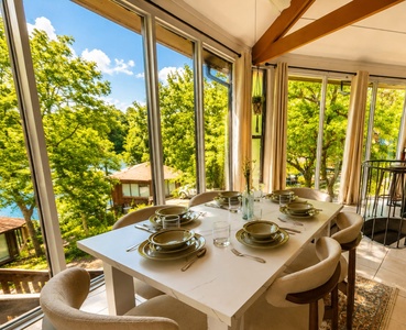 Gather for a meal surrounded by wall-to-ceiling windows framing lush treetops and glimpses of shimmering lake water. Natural light fills your dining space, making every breakfast or sunset dinner feel special.