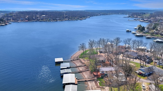 Stunning aerial view of the lakefront property area, showcasing the beautiful blue waters and surrounding neighborhood with private docks.