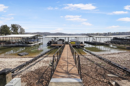 Lakefront marina with covered boat slips and wooden dock access to the water for boating adventures.