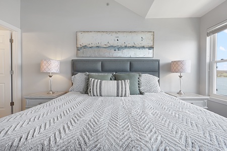 Sink into this plush king bed with its textured linens and soft pillows for the perfect night's rest.