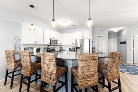 Your chef's paradise awaits with granite counters, gleaming appliances, and cozy wicker seating for morning coffee or evening gatherings.