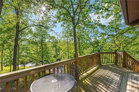 The property offers a scenic setting surrounded by lush forest. The outdoor deck provides a peaceful spot to relax while taking in the natural wooded landscape and fresh air.