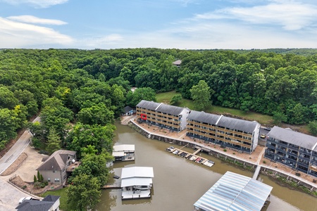 This lakeside property sits nestled in lush forest, offering waterfront access with private boat docks and covered slips, surrounded by rolling wooded hills and peaceful natural scenery.