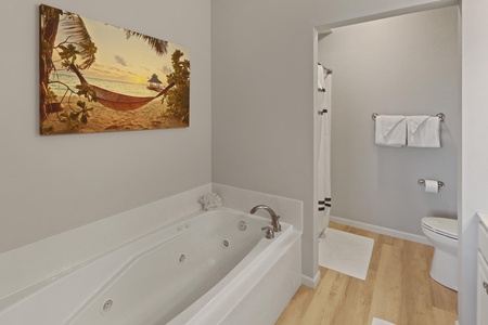Unwind in your private spa-like bathroom featuring a jetted soaking tub and separate shower, complete with fluffy towels.