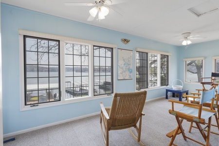 Relax in this serene lakefront room with panoramic water views through oversized windows and comfortable seating for your peaceful getaway.