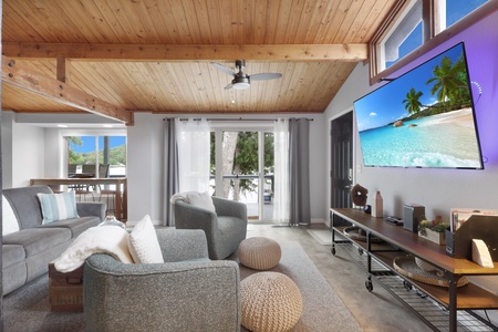 Sink into plush seating beneath warm wood ceilings as natural light floods your living space. Your private retreat features a large TV for cozy evenings and opens to outdoor dining with serene views.