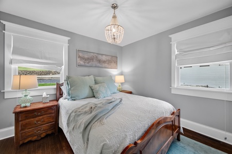 Rest easy in this serene bedroom where soft lighting and a sparkling chandelier create a peaceful retreat for your stay.