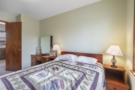 Unwind in your peaceful bedroom with warm lighting and comfortable bedding that promises restful nights.