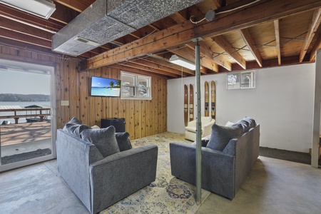 Unwind in your cozy basement lounge with exposed beams, comfy seating, and vintage ski decor creating the perfect après-ski retreat.