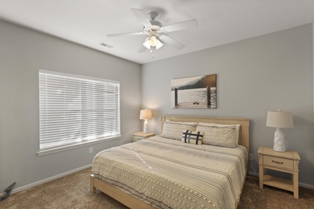 Drift off in your cozy bedroom with soft natural light, gentle ceiling fan, and serene lake artwork creating the perfect retreat.