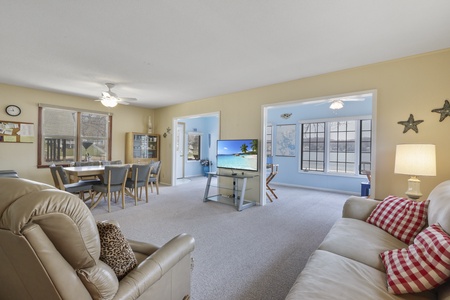 Relax in your spacious open-plan living area with plush seating, modern TV setup, and cheerful dining space perfect for family gatherings.