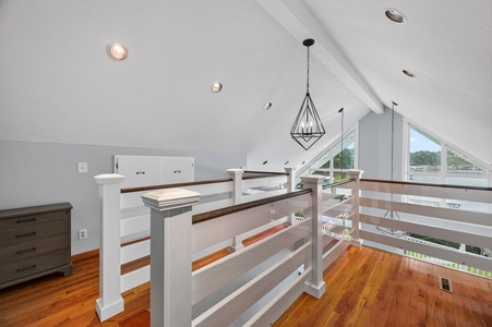 Soaring vaulted ceilings and rich hardwood floors create an airy loft space, while large windows frame serene water views and fill your retreat with natural light.
