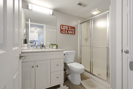 Your bright bathroom features a spacious vanity and glass-door shower, perfectly appointed for your comfort.