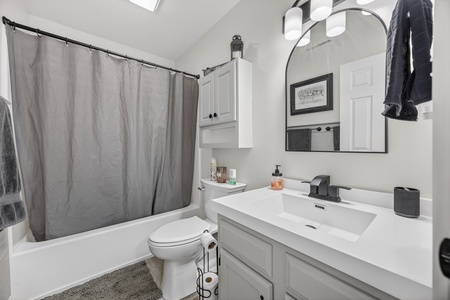 Step into a bright, thoughtfully designed bathroom with crisp white finishes, modern fixtures, and a skylight that fills the space with natural light. Fresh towels and toiletries await your arrival.