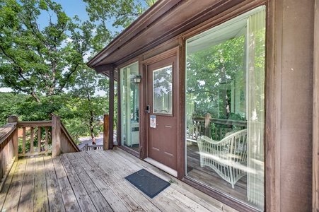 The property entrance features a welcoming deck surrounded by mature trees and peaceful natural scenery, offering a tranquil setting for your arrival.