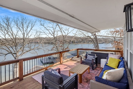 Unwind on your private covered deck with stunning lake views and cozy outdoor seating perfect for morning coffee or evening relaxation.