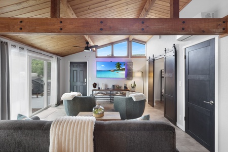 Unwind in your bright living space with soaring wood-beamed ceilings, cozy seating, and large windows framing natural light and views—your perfect retreat awaits.