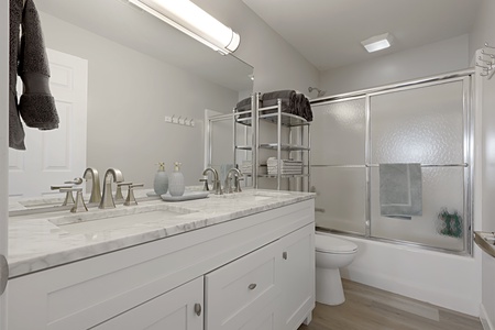 Refresh in your modern bathroom with dual sinks, marble countertops, and spacious shower-tub combo—perfect for unwinding after your adventures.