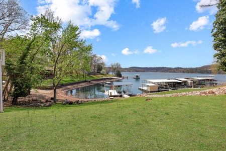 Scenic lakefront property with private dock access and expansive grounds surrounded by rolling hills and natural beauty.
