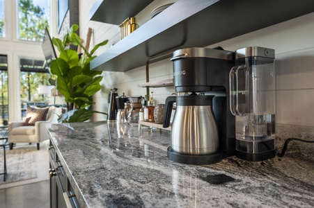 Coffee bar has a Keurig coffee pot, French press, and complimentary flavor additions
