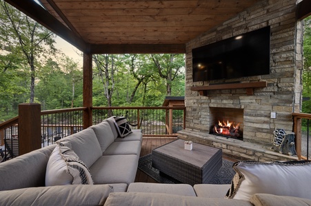 Outdoor entertaining area with sectional seating, gas fireplace, and TV