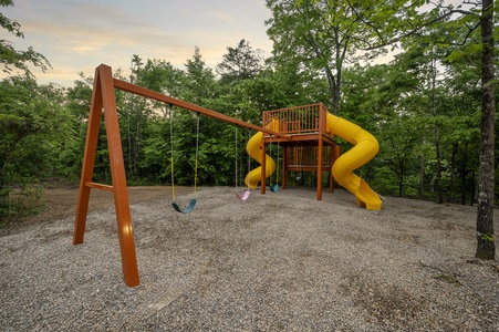 Custom playset with two slides, swings, and rock climbing wall