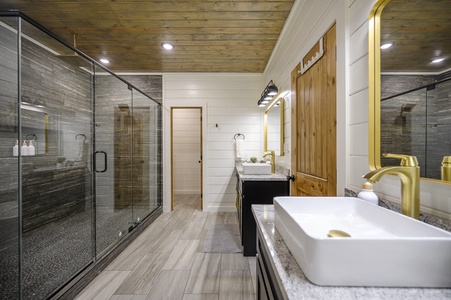 Downstairs master bathroom features a double vanity, soaker tub, and spacious walk-in shower