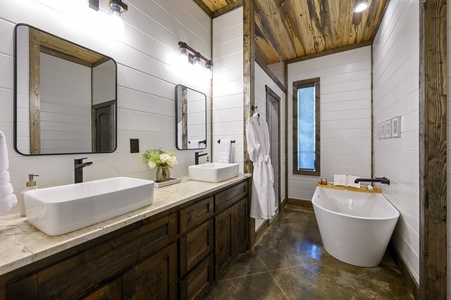 Ensuite bathroom with double vanity, soaking tub, and walk-in shower