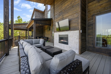 Outdoor entertainment area by gas fireplace and Smart TV
