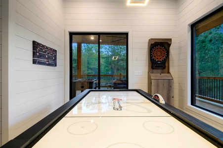 Game room with arcade, card table, darts, and air hockey