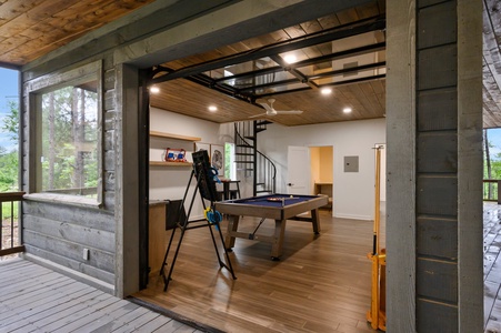 Game room with retractable garage door opening to back deck