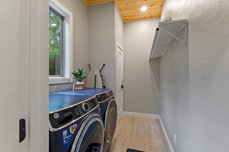 Laundry room with iron, ironing board, and coat closet