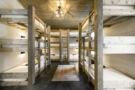 Spacious bunk room split into two sides each with 4 sets of triple-stacked twin bunks