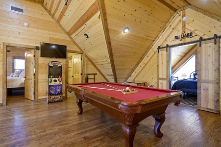 Upstairs game room with pool table and arcade games
