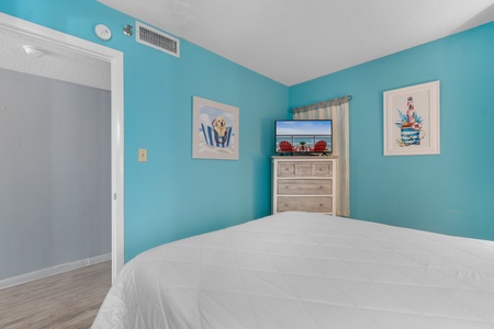 Drift off in this tranquil coastal bedroom where turquoise walls and beach art create your seaside sanctuary.