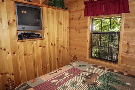 TV in the wall at foot of bed at Seclusion, a 1 bedroom cabin rental located in Gatlinburg