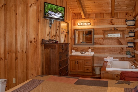 Jacuzzi, bathroom vanity, TV, and dresser in the bedroom at Blue Mountain Views, a 1 bedroom cabin rental located in Pigeon Forge