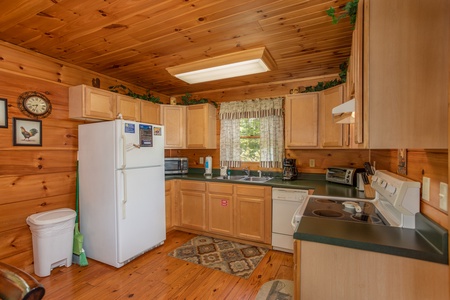 Kitchen with white appliances at Hillside Haven, a 1 bedroom cabin rental located in Pigeon Forge